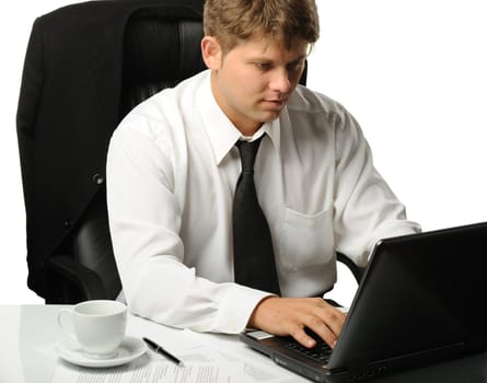The young businessman on a workplace. It is isolated on a white background