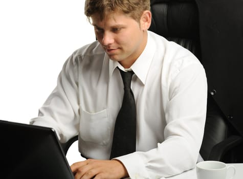 The young businessman on a workplace. It is isolated on a white background