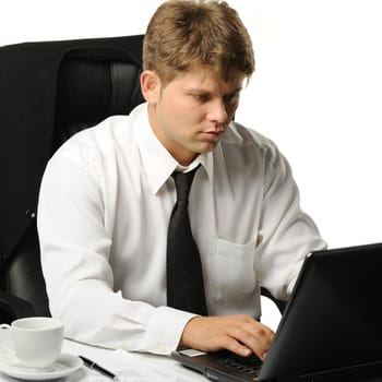 The young businessman on a workplace. It is isolated on a white background