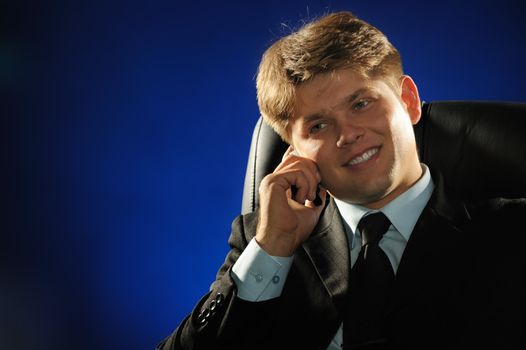 The businessman talking by a mobile phone. Young the man of the European appearance