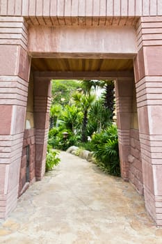 Stone gate entrance to a tunnel-shaped luxury hotel.