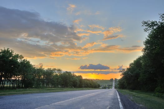 Road and sunset. An automobile line and a red sunset