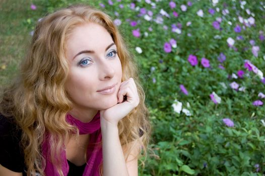 Red-headed woman among violet flowers in park