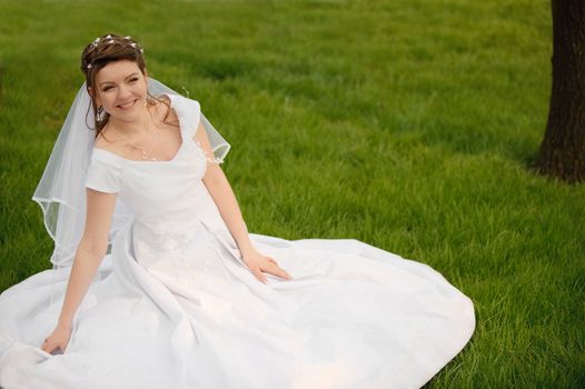 The bride on a lawn. The young girl in a wedding dress.