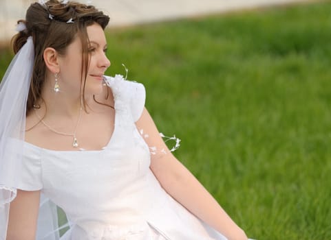 The bride on a lawn. The young girl in a wedding dress.