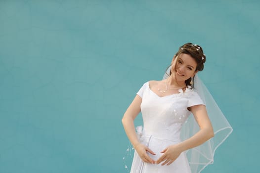 The dancing bride. The young girl in a wedding dress on an abstract background. East dance