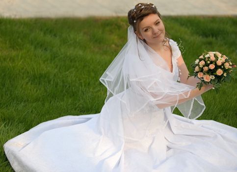 The bride on a lawn. The young girl in a wedding dress.