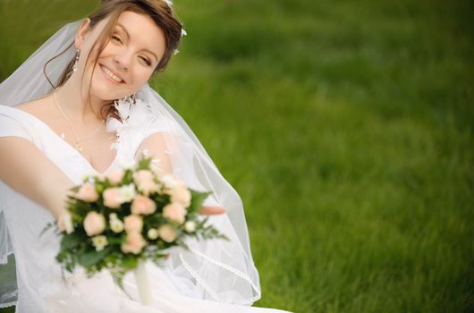 The bride on a lawn. The young girl in a wedding dress.