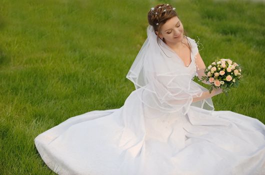The bride on a lawn. The young girl in a wedding dress.
