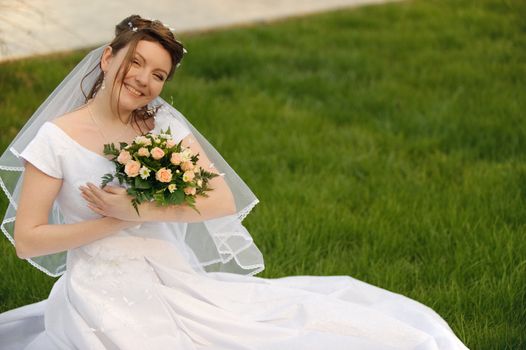 The bride on a lawn. The young girl in a wedding dress.