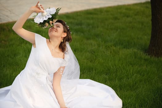 The bride on a lawn. The young girl in a wedding dress.