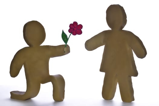 Plasticine toys Astickman on white background.boy are given to the girl by a flower
