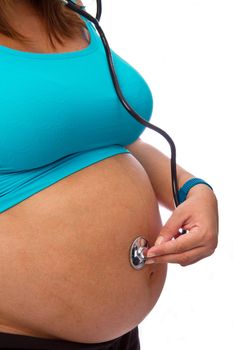 Pregnant woman hear with a stethoscope isolated on white