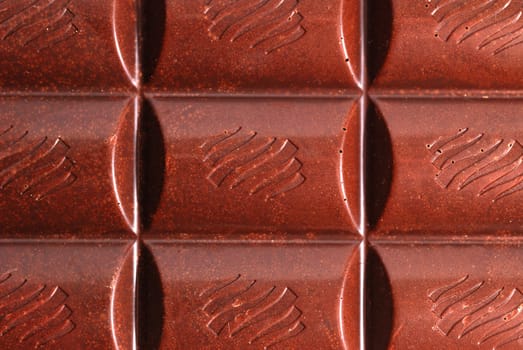Chocolate. The broken tile of porous black chocolate