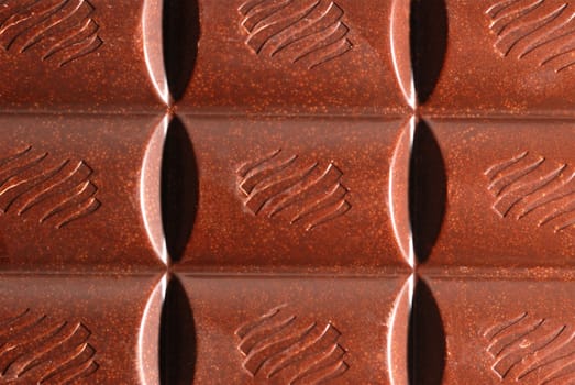 Chocolate. The broken tile of porous black chocolate