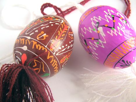 Easter eggs painted by bright paints   - with the passed cords (handmade) - isolated white background  - with the passed cords