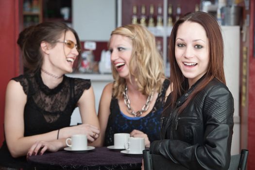 Three young friends joking and laughing in a bistro