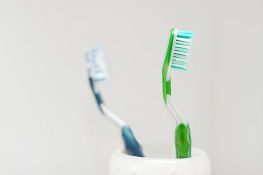 Toothbrushes closeup, only one of them in focus