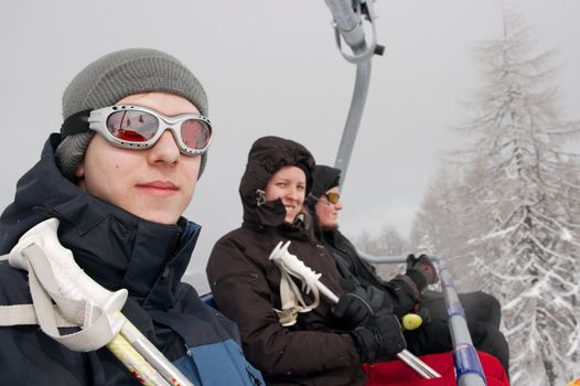 Skiers sitting in a ski lift