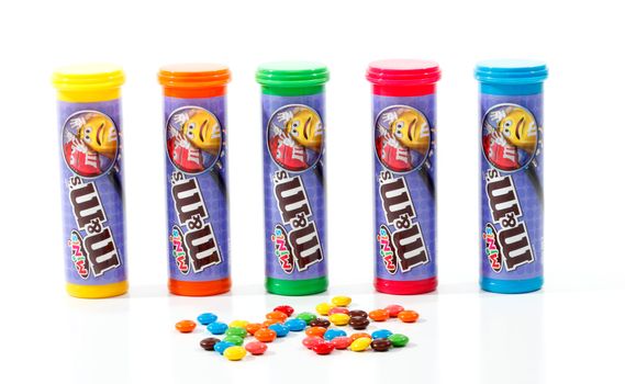 Bright colourful tubular containers of M&M Minis, containing small versions of the traditional M&M in colours of red, green, orange, brown, yellow and blue.  Over 100 minis in each tube.