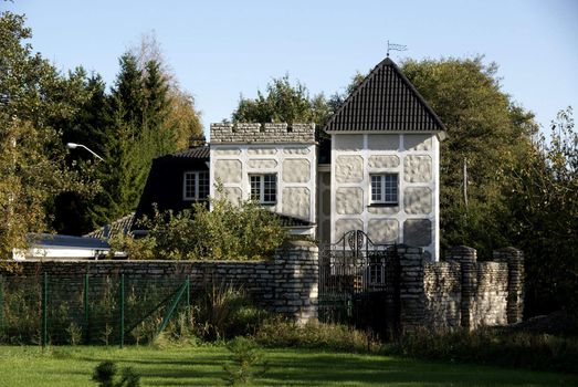 The modern house is behind a fence