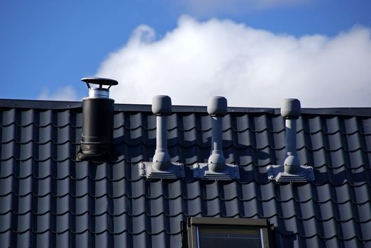 Pipes of ventilation are located on a roof of a building