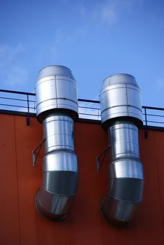 Pipes of ventilation are located on a wall of a residential building
