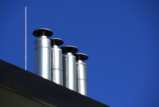 Pipes of ventilation on a background of the blue sky