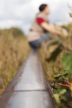 woman sitting on the rail road. The focus of the railroad, a man presented as a symbol