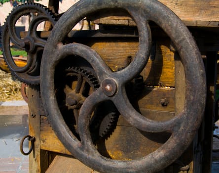 A number of cogwheels on a old agricultural machine