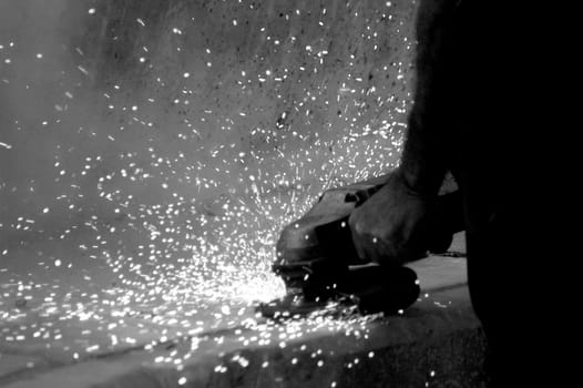 A man saws a portion of steel before a concert.
