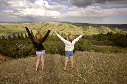 Cypress Hiils Canada conglomerate cliffs Saskatchewan view 2 girls arms in air