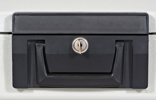 Front of a fire proof lock box with key in keyhole