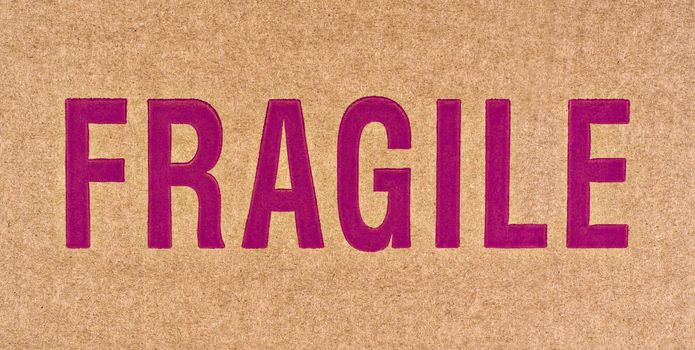 The word FRAGILE in red on a brown cardboard box.
