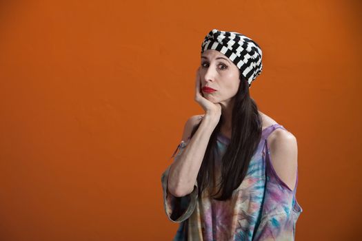 Mexican American woman wearing a tie-dye shirt in a misarable mood