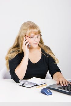 office worker. Blonde girl with laptop talking on a cell phone