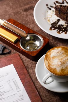 check, ashtray, cigar, lighter and coffee at restaurant table