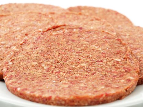 Raw hamburger meat on white plate, towards white background, isolated