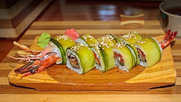 Roll tempura with a big shrimp on a wooden tray