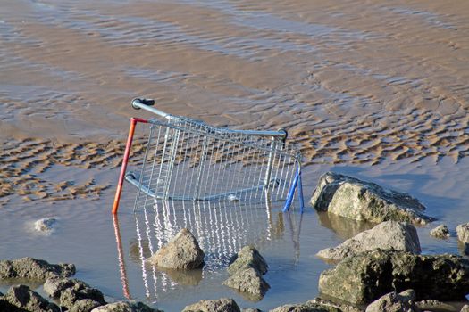 disguarded shopping trolly on blackpool beach