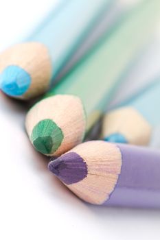 Four colorful crayons on white background with a shallow depth of field for effect.