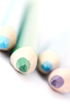 Four colorful crayons on white background with a shallow depth of field for effect.