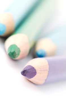 Four colorful crayons on white background with a shallow depth of field for effect.