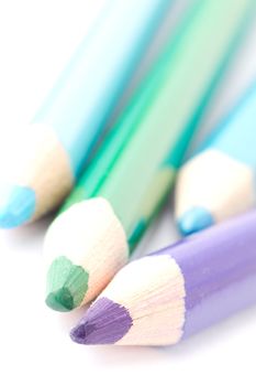 Four colorful crayons on white background with a shallow depth of field for effect.