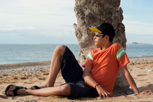 Cool looking teenager relaxing on the beach