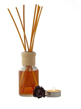 Sticks of scent, lite candle and dried red rose