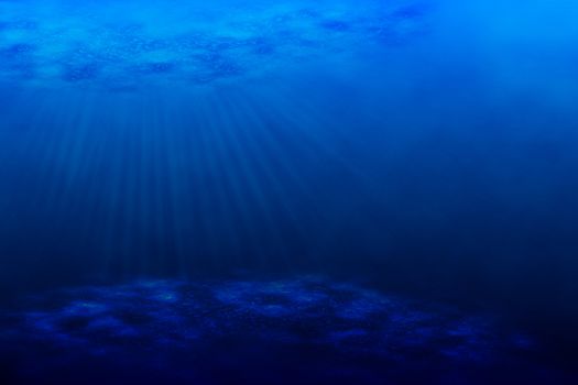 An underwater scene with sun rays shining through the water's glittering and moving surface.