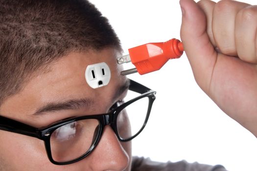 Conceptual image of a young man holding an electrical chord unplugged from the outlet on his forehead.