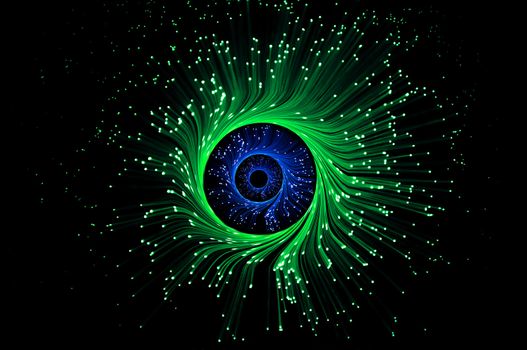 Three rings of illuminated green and blue fiber optic light strands against black background