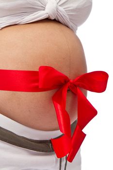 Pregnant woman with red ribbon on belly isolated on white